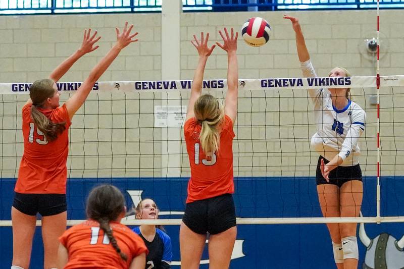 Geneva’s Emma Peterson (15) goes up for a kill attempt against Wheaton Warrenville South's Katie Dragas (15) and Alison Coyne (13) during a DuKane Conference match in Geneva on Tuesday, Sept. 16, 2025.