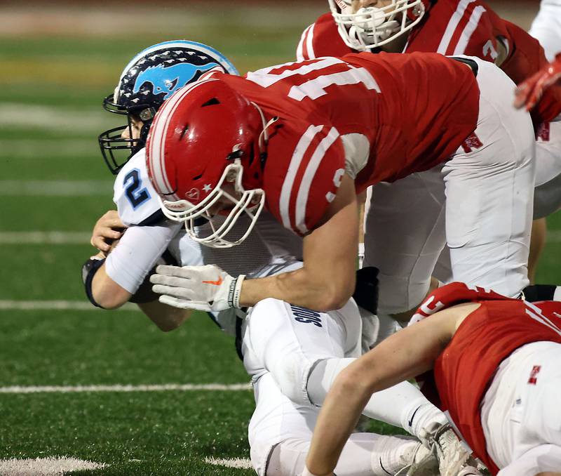 Downers Grove South's Will Potter (2) is wrapped up by Naperville Central's Jude Sutherland Friday October 27, 2023 in Naperville.