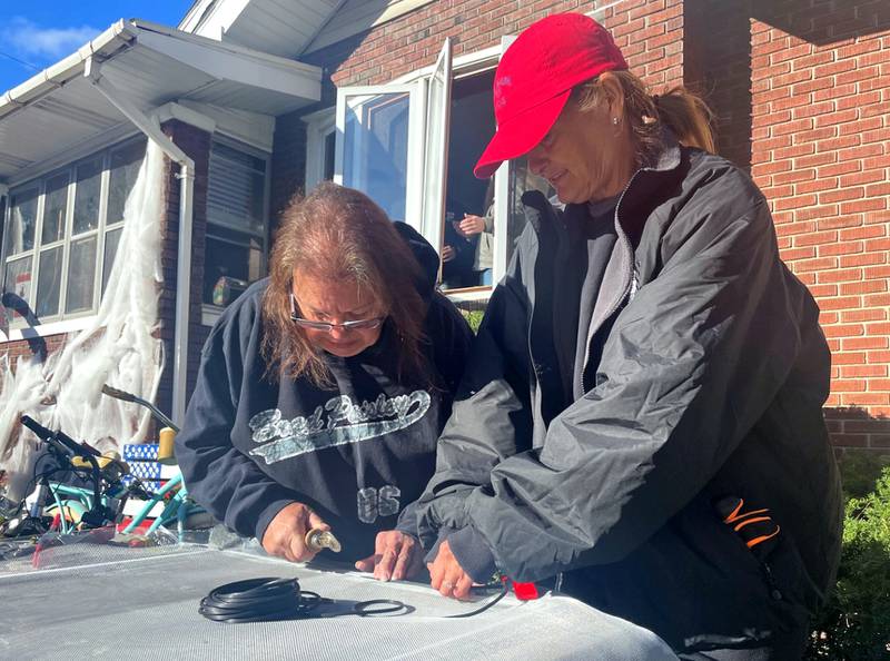 Lori Ceja (left) and Angie Wilson repair window screens during United Way of Eastern La Salle County's 2023 Labor of Love project at a home in the 700 block of West Main Street in Ottawa.