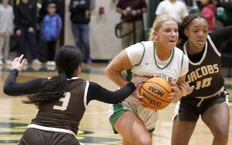Crystal Lake South's Laken Lepage (center) is fouled by Jacobs' Sophia Acot (left) as drives the lane between Acot  and Jacobs' Zara Lewis (right) during a Fox Valley Conference basketball game on Friday, Jan. 17, 2025, at Crystal Lake South High School.