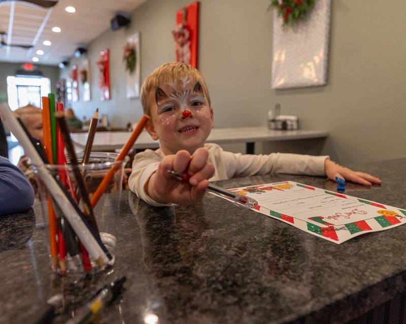 Riley Waynick waves at camera at the annual Christmas in the Valley on Saturday, November 15, 2025 at the Tee Box in Spring Valley.