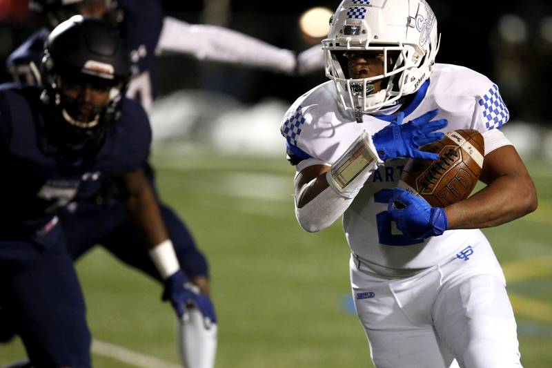 St. Francis’s Terreon Roundy runs the ball during their football game at Plunkett Park in Elmhurst, Ill., on Friday, March 19, 2021.