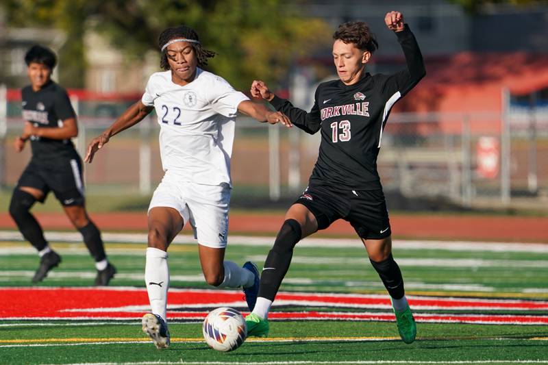 Oswego East's MJ Hoffman (22) challenges Yorkville's Alex Arriaga (13) for the ball during a soccer match in October at Yorkville High School.