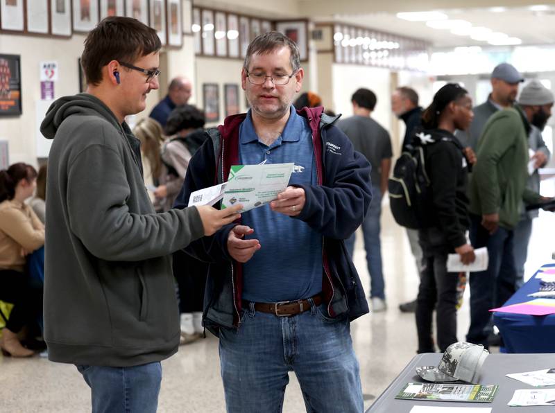 Attendees look over information Wednesday, Oct. 22, 2025, during Trades Exploration Day at DeKalb High School. The event hosted several companies and organizations that were offering information on opportunities in the trades.