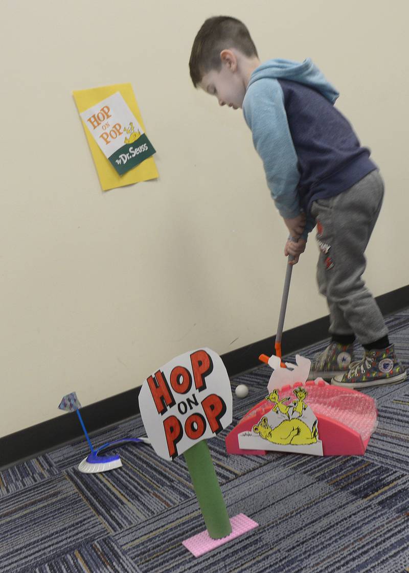 Crosby Tomano plays a difficult "Hop On Pop" hole Thursday, March 7, 2024, at the Reddick Library in Ottawa during a special Dr. Seuss miniature golf outing to celebrate the author’s recent birthday.