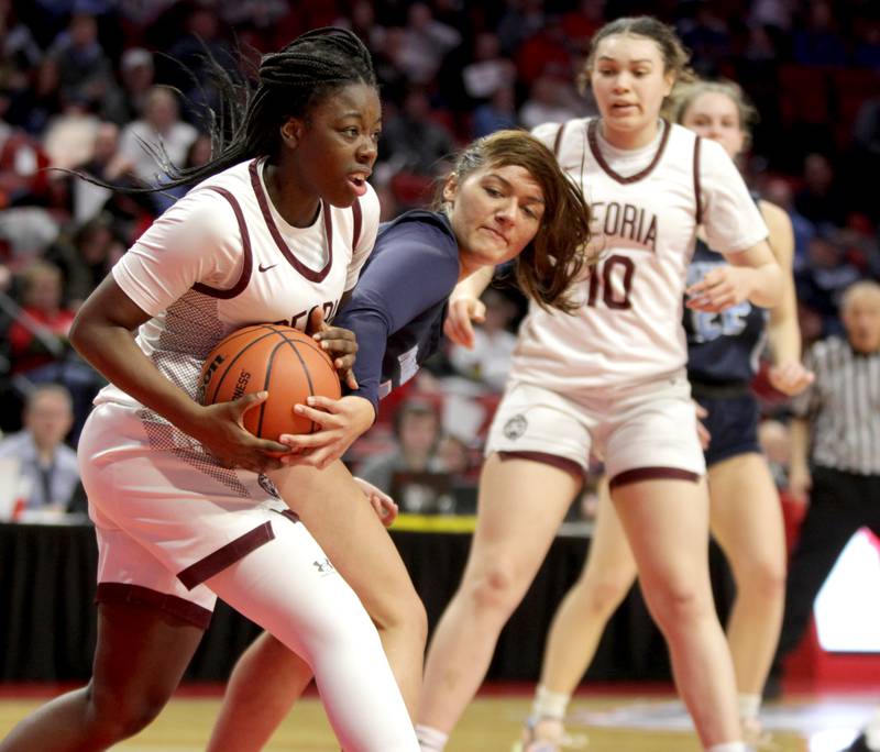 Nazareth Academy's Danielle Scully (right) tries to grab the ball from Peoria’s Niasha Rutherford (left) during the Class 3A girls basketball state semifinal at Redbird Arena in Normal on Friday, March 3, 2023.