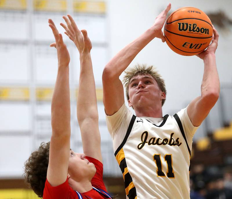 Jacobs' Carson Goehring tries to shoot the ball over Dundee-Crown's Hudson Reardon during a Fox Valley Conference boys basketball game on Tuesday, February. 3, 2026, at Jacobs High School in Algonquin.