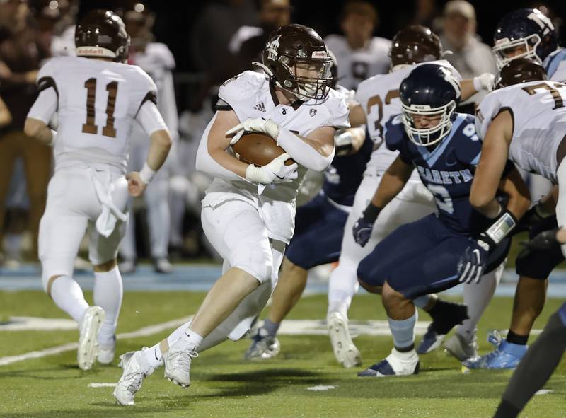 Joliet Catholic's Lawrence Stringham (24) carries the ball during the varsity football game between Joliet Catholic and Nazareth academies on Friday, Sep. 27, 2024 in La Grange Park.
