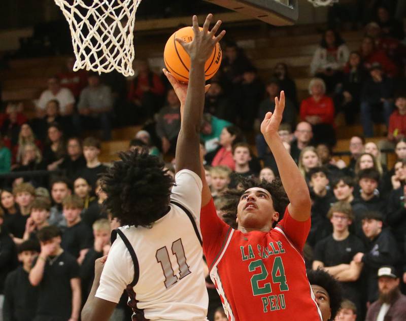 L-P's Marion Persich has his shot blocked by Peoria's Cameron Gunn during the Class 3A Sectional semifinal game on Wednesday, March 5, 2025 at Washington High School.