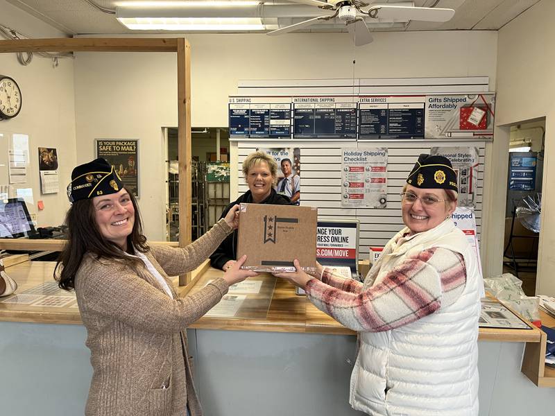 Commander Cynthia Reynolds and Adjutant Marddi Rahn hand a Battle Buddy Box to Post Master Janette Krontz for delivery to a deployed service member.
