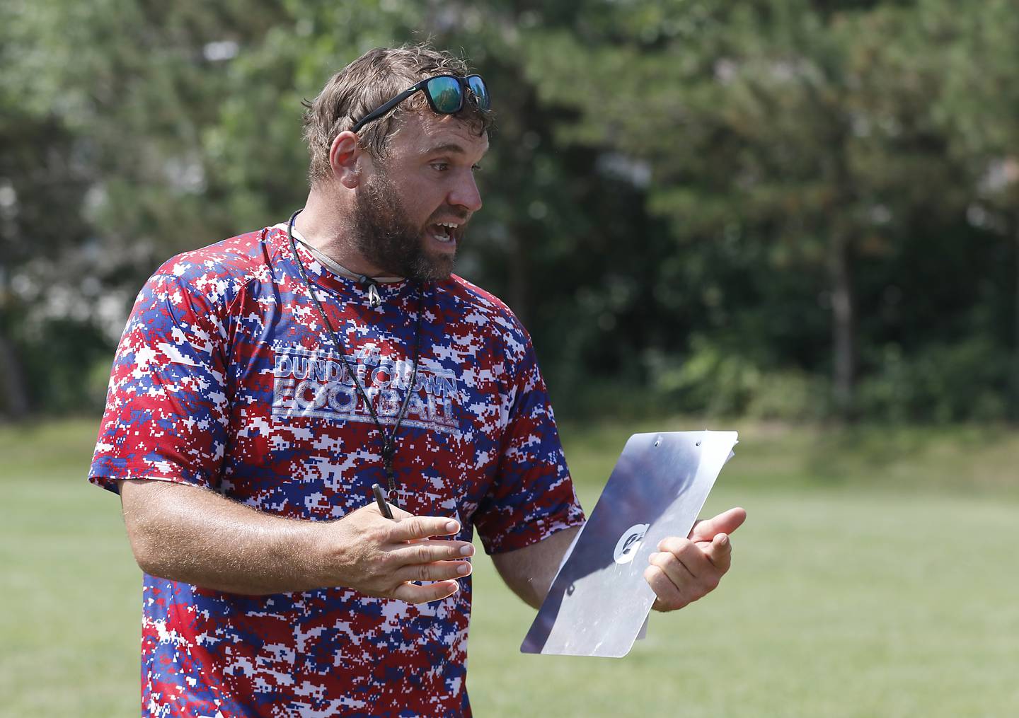 Dundee-Crown Head Coach Michael Steinhaus calls in a play during football practice on Tuesday, July 29, 2025, at Dundee-Crown High School in Carpentersville.