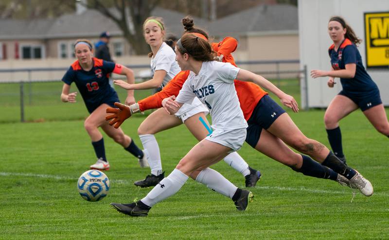 Oswego East's Taylor English (14) shoots the ball for a goal against Oswego’s Margaret Leger (0) during a soccer match at Oswego High School on Monday, May 2, 2022.