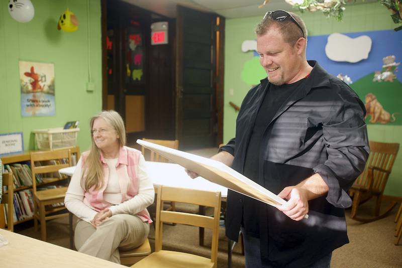 Handwriting analyst Chris McBrien studies some handwriting samples during a handwriting analysis program at the Clinton Township Public Library July 9.