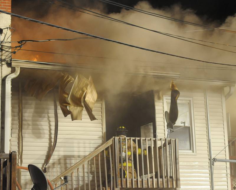 A firefighter enters a buring building above Skoogs Pub & Grill on Sunday, May 10, 2015 downtown Utica.