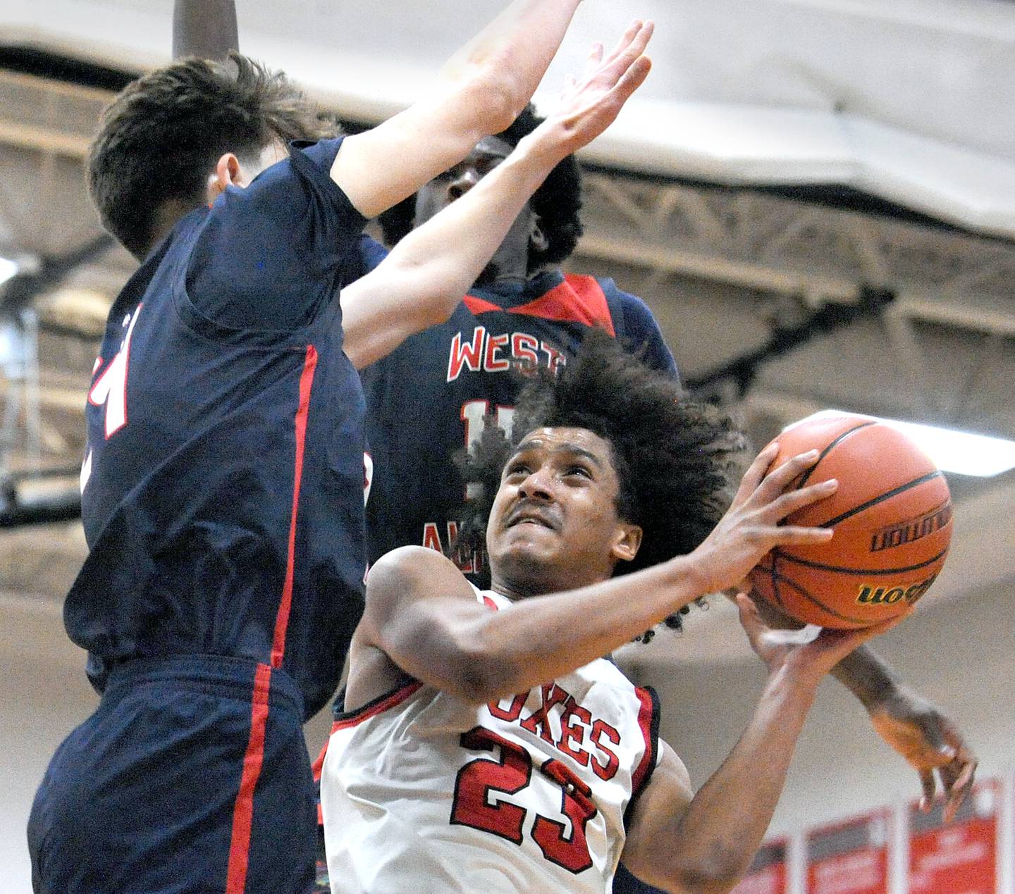 Yorkville's Jory Boley (23) looks for a shot and draws a foul from two West Aurora defenders during a class 4A regional semifinal basketball game at Yorkville High School on Wednesday, Feb. 21, 2024.