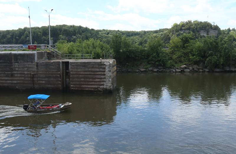 71 year old adventurer and thyroid cancer survivor Robert Youens, exits the Starved Rock Lock and Dam with the Starved Rock iconic landmark behind him on Monday, July 28, 2025 near Utica. Youens is making  the Great Loop, a 6,000 mile journey on his Jon boat something that hasn't been done before. Youens is looking at setting a record for the longest someone has gone on a Jon boat.