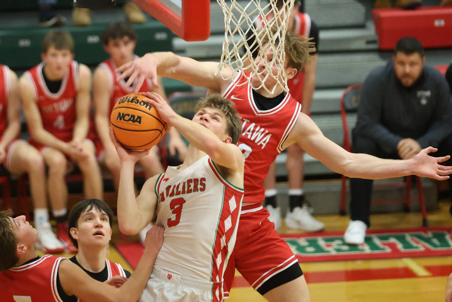 L-P's Braylin Bond eyes the hoop as Ottawa's Owen Sanders puts a finger on the ball on Friday, Jan. 9, 2026 in Sellett Gymnasium at L-P High School.