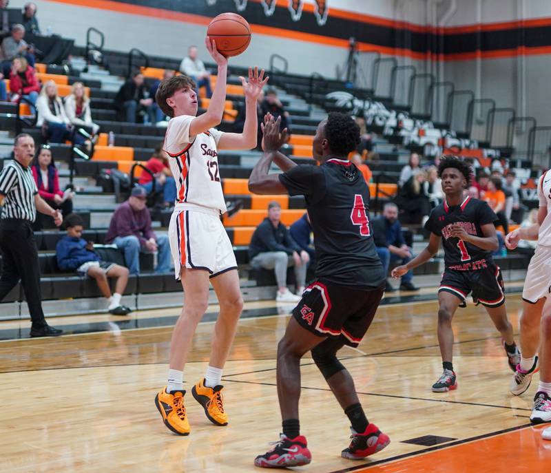 St. Charles East's Sam Tisch (12) shoots the ball on the wing against East Aurora's Kenneth Cooley (4) during the 64th annual Ron Johnson Thanksgiving Basketball Tournament at St. Charles East High School on Monday, Nov 20, 2023.