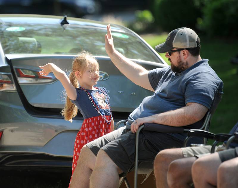 Four-year-old MacKenzie Kiefer of Oswego, high-fives her dad Robert as marching band music could be heard down Main Street during the annual Memorial Day Parade and Service, Monday, May 29, 2023.