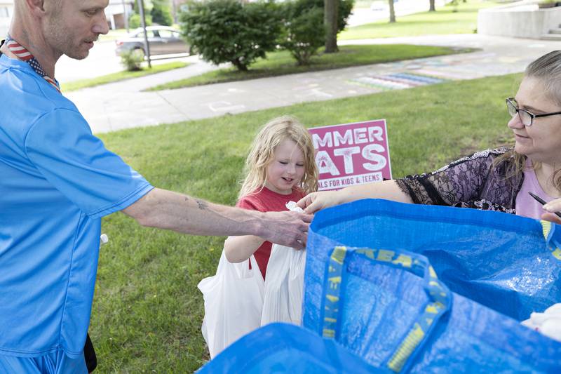 Jonathan Webb and daughter Emery, 5, pick up lunch Wednesday, July 16, 2025, at Lincoln School in Dixon from Tina Adcock.