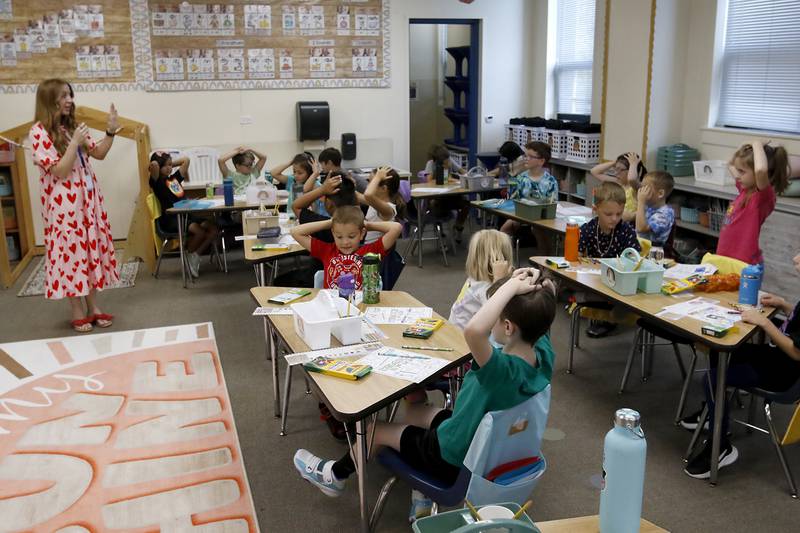 Teacher Katie Ward tells her student what they are going to do next during the first day of school for McHenry's Landmark Elementary School on Wednesday, July 17, 2024.