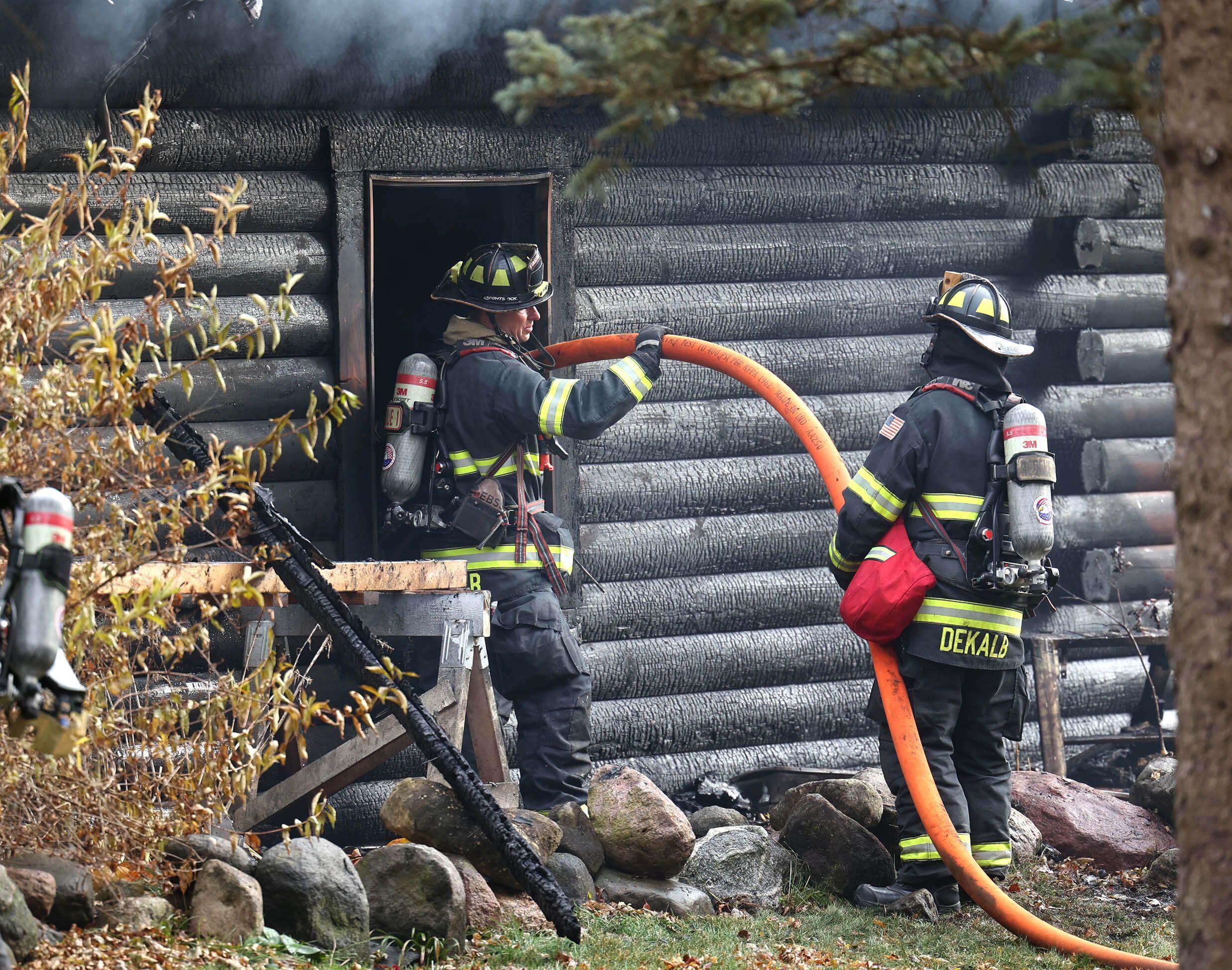 DeKalb firefighters feed a hose through a window on a house that was destroyed by fire Thursday, Nov. 13, 2025, near Shabbona Grove Road in Shabbona. Several local departments responded to the general alarm structure fire.