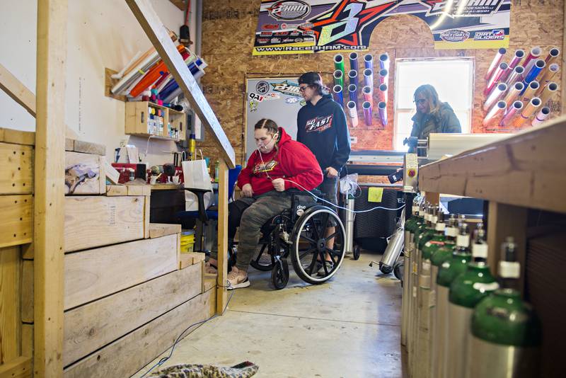 Attached to a tank of oxygen, Carlie is wheeled to the stairs at her Dixon home. “I never thought I’d see my house again,” Hamburg said after arriving home.