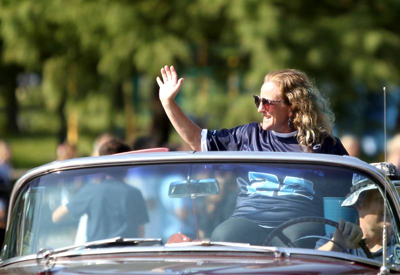 Downers Grove South Principal Arwen Lyp waves to onlookers during the school's homecoming parade on Friday, Sept. 16, 2022.
