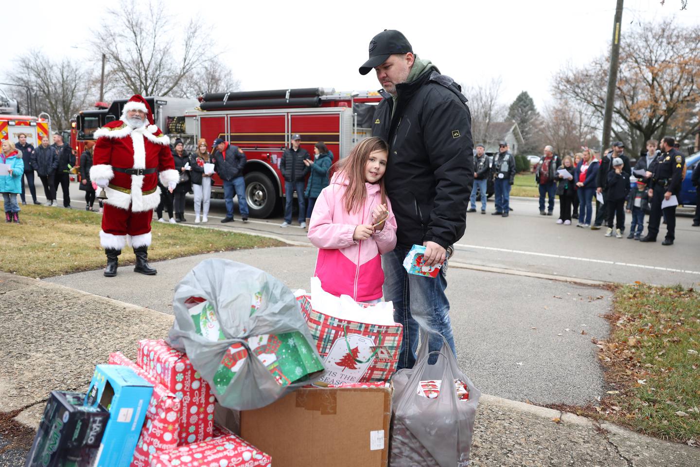 Jeff Jenicek stands with daughter Alexa, 8, near a pile of gifts donated by the non-profit charity Lockport Love on Saturday, Dec. 10, 2022, in Lockport.