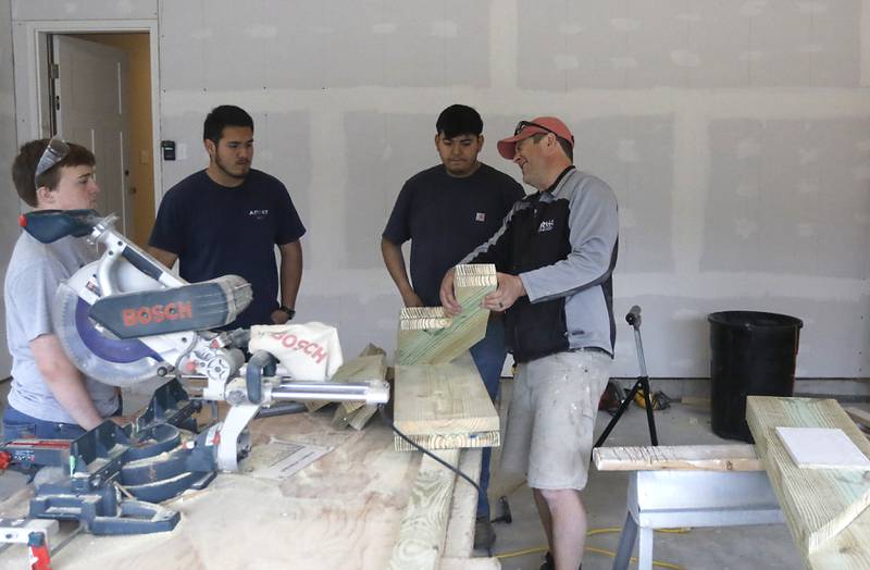 Erich Parpart teaches students in the Woodstock Building Trades Program how to build stairs Monday, May 8, 2023, in the home they are building in Woodstock. This will be the program's 43rd completed home since it began in 1972.