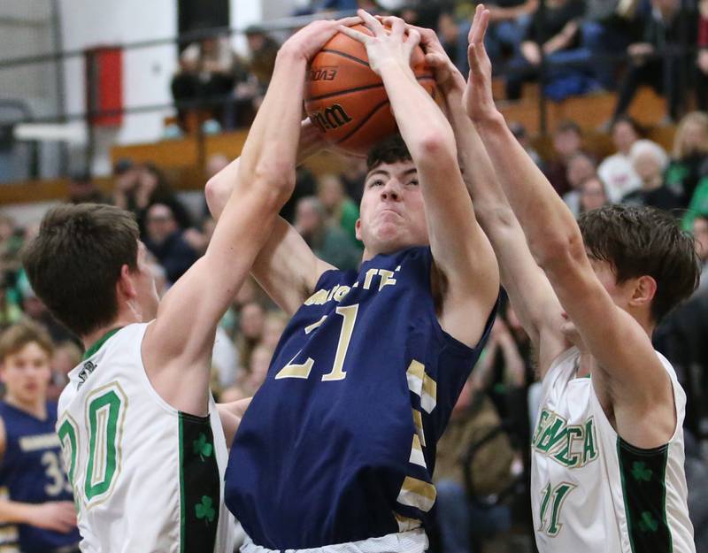 Marquette's Carson Zellers (center) fights his way through Seneca defenders Calvin Maierhofer and John Farcus during the Tri-County Conference championship game on Friday, Jan. 27, 2023 at Putnam County High School.