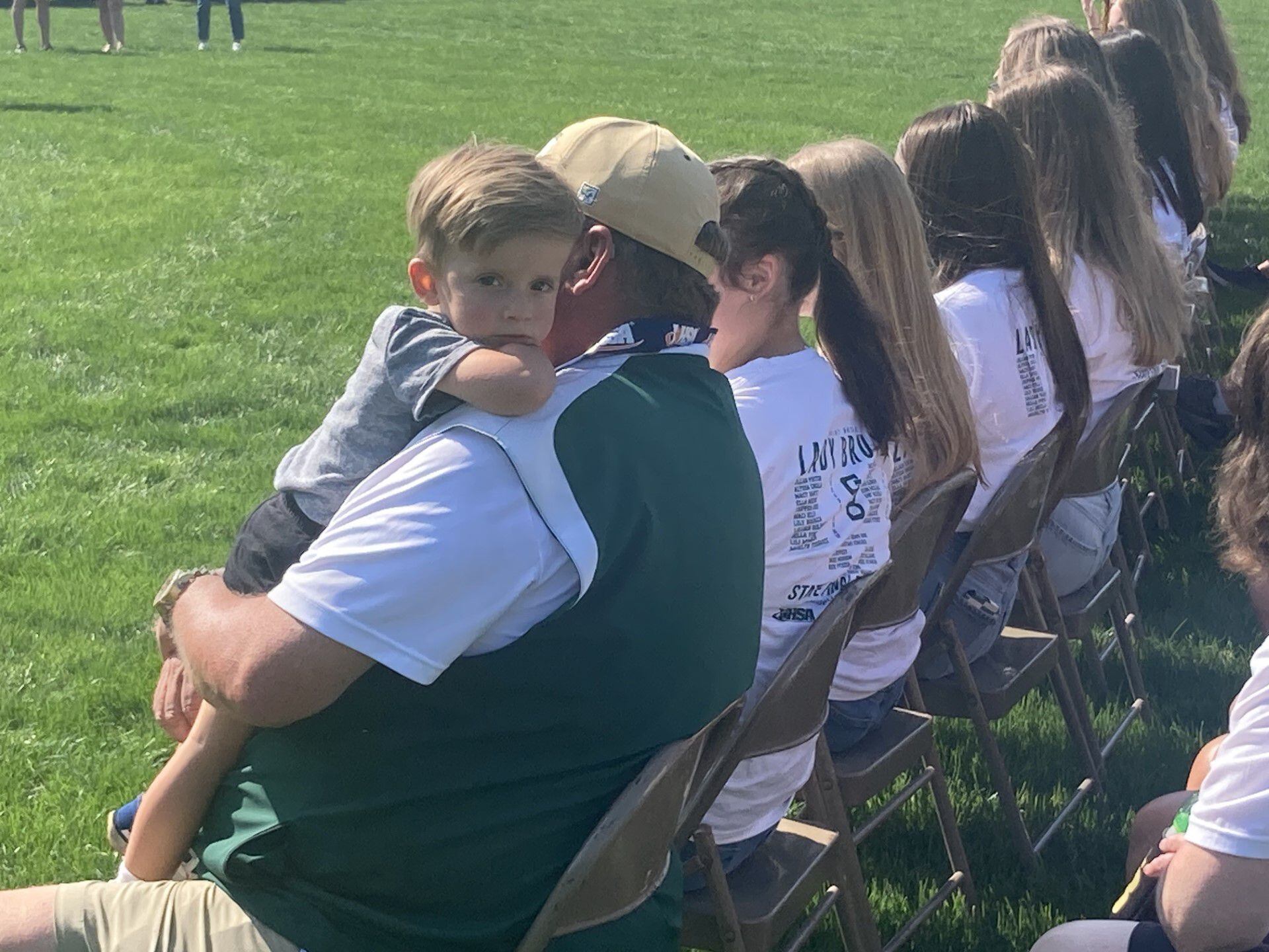 St. Bede coach Shawn Sons holds onto his grandson during the state championship ring ceremony for the Bruins softball team Saturday.
