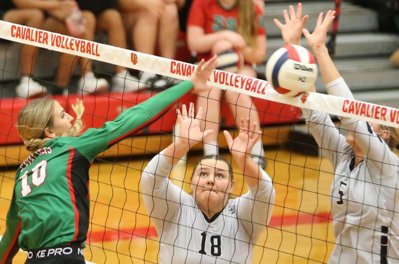 L-P's Kelsey Frederick spikes the ball past Kaneland's Leah Shirley and teammate Kayli Loonam in AJ Sellett Gymnasium on Thursday, Oct. 24, 2024 at L-P High School.
