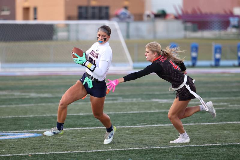 Oswego's Sophie Augustine runs the ball as Yorkville's Grace Niles secures her flag during the Foxes' 2-1 overtime victory over Oswego in the IHSA Kankakee Regional championship game on Thursday, Oct. 9, 2025.