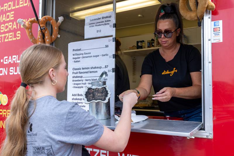 (left to right) Alice Scruggs purchases pretzel from Margit Begly of “Didoughs Pretzels” at the annual Shrimp Fest on Saturday, June 7, 2025 at Rotary Park in Princeton.