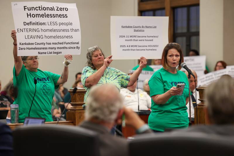 Fortitude Community Outreach supporter Misty Chouinard speaks to Kankakee City Council members as fellow supporters hold up informational signs during public comment ahead of the council's vote on a conditional use permit to allow Fortitude to operate a shelter at 970 E. Court St. in Kankakee during the meeting on Monday, Sept. 15, 2025. The conditional use permit request was rejected by a 12-0 vote.