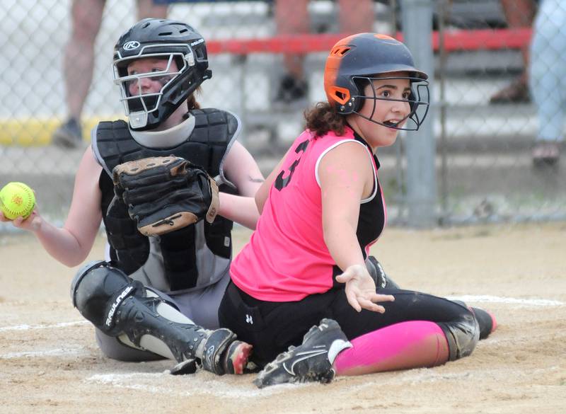 American Family Insurance baserunner Kaylee Henert (3) reacts after being tagged out at the plate by MJ Track Works catcher Carmen Turner during the Streator Girls Softball 12-15 Division championship game at Bodznick Field on Friday, July 14, 2023.
