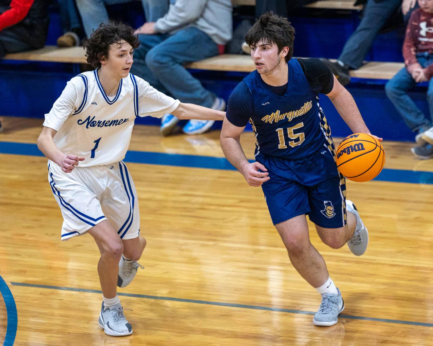 Marquette's Alec Novotney (15) drives ball down lane as Eli Swenson (1) of Newark guards on Thursday, January 22, 2026 at Newark High School in Newark.