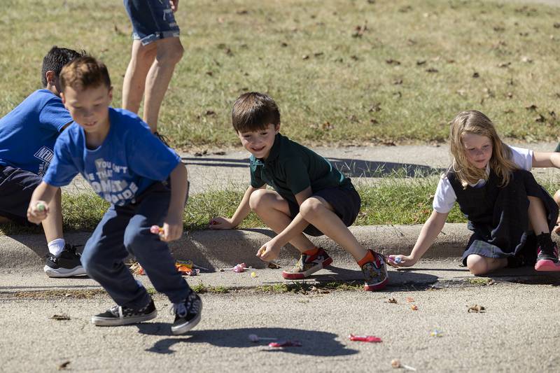 Students scramble to snatch up candy Friday, Sept. 20, 2024, during Newman High School’s homecoming parade. Catholic school students from the area attended Friday’s parade.