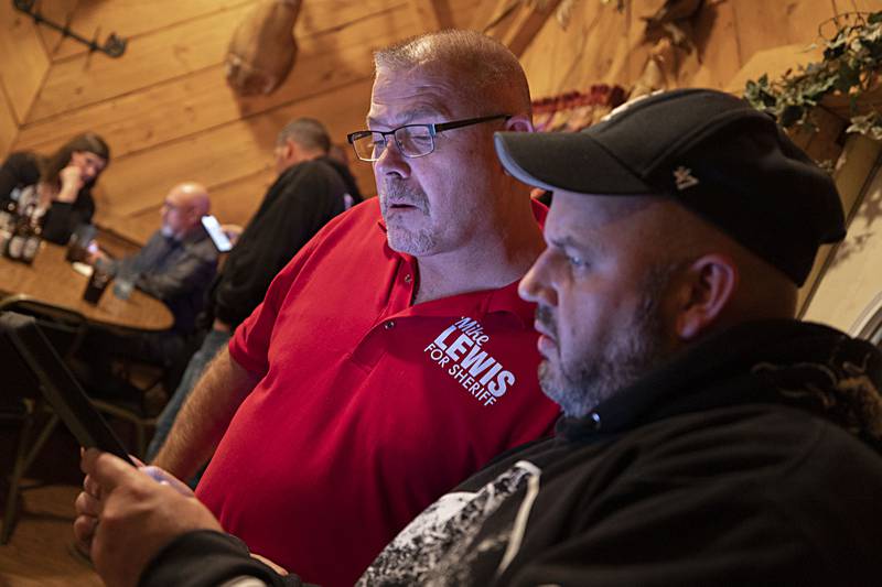 Whiteside County sheriff candidate Mike Lewis (left) checks results during an election party Tuesday, Nov. 8, 2022 at Wagon Wheel in Sterling.