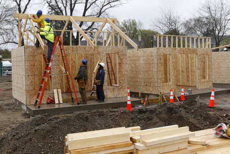 Volunteers construct tiny shops Monday, May 1, 2023, at the new McHenry Riverwalk Shoppes at Miller Point Park in McHenry. McHenry High School students joined volunteers from Habitat for Humanity of McHenry County, McHenry Parks and Recreation Department staff, and contractors to build the shops at the site.