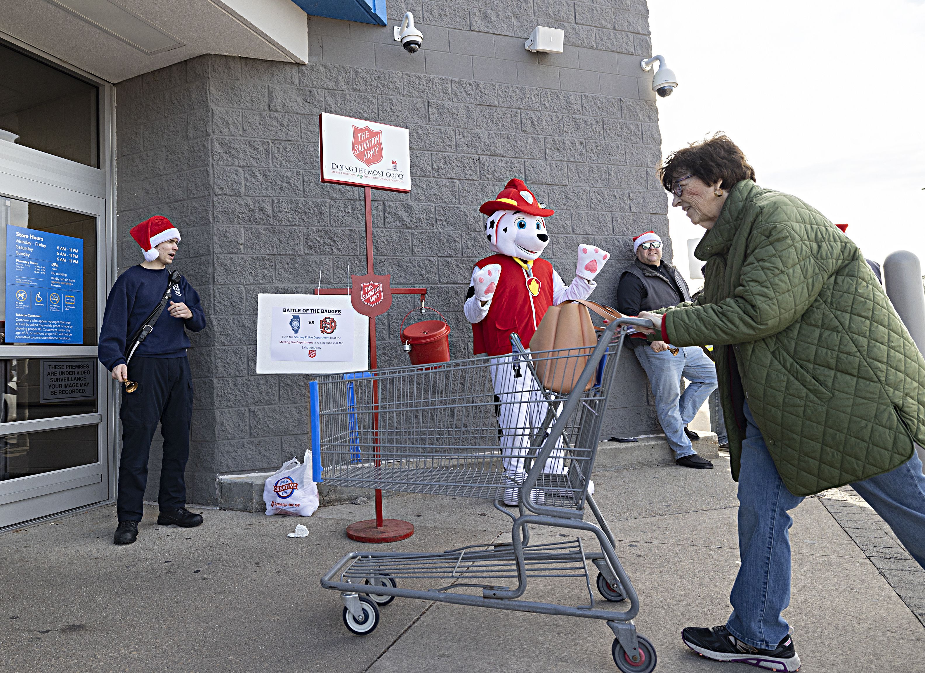 Sterling firefighter Kyle Bell and the Sterling fire mascot greet shoppers Friday, Dec. 15, 2023 at the Sterling Walmart. The fire and police departments both manned the Salvation Army buckets on Friday for a friendly competition on who could collect the most money. Winner gets the City Trophy and has bragging rights the next year.