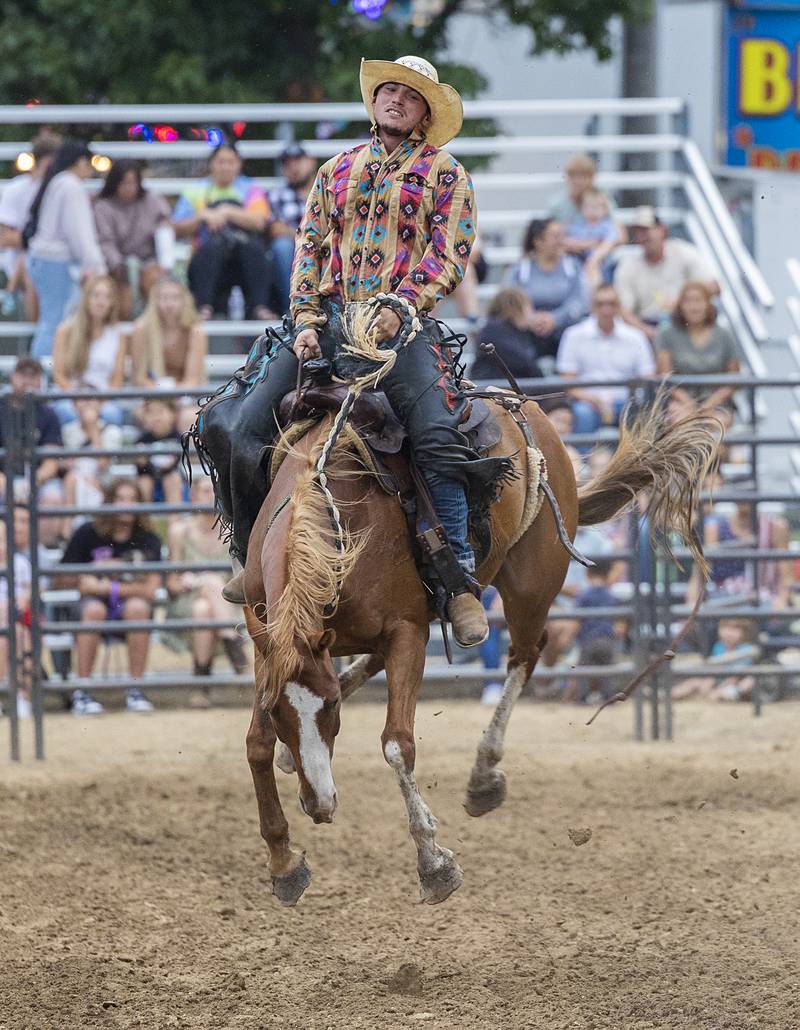 Bronc rider Devon Eastman handles “Dirty Mike” Wednesday, August 14, 2024, at the Whiteside County Fair in Morrison.
