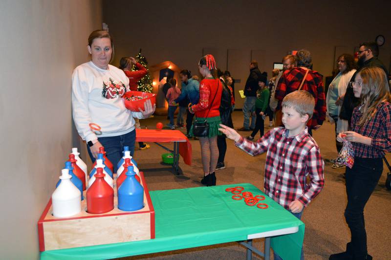 Lincoln Bocker, 6, of Polo, plays a ring toss game at Crossroad Community Church's Winter Carnival on Saturday, Dec. 2, 2023. The Winter Carnival was part of the fifth annual Polo Christmas Festival.