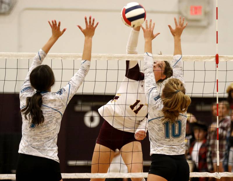 Richmond-Burton's Maggie Uhwat, center, tries to hit the ball through the block of Woodstock North's Daniela Medina, left, and Danielle Hansen, right, during a Kishwaukee River Conference volleyball match Wednesday, Sept. 14, 2022, between Richmond-Burton and Woodstock North at Richmond-Burton Community High School.