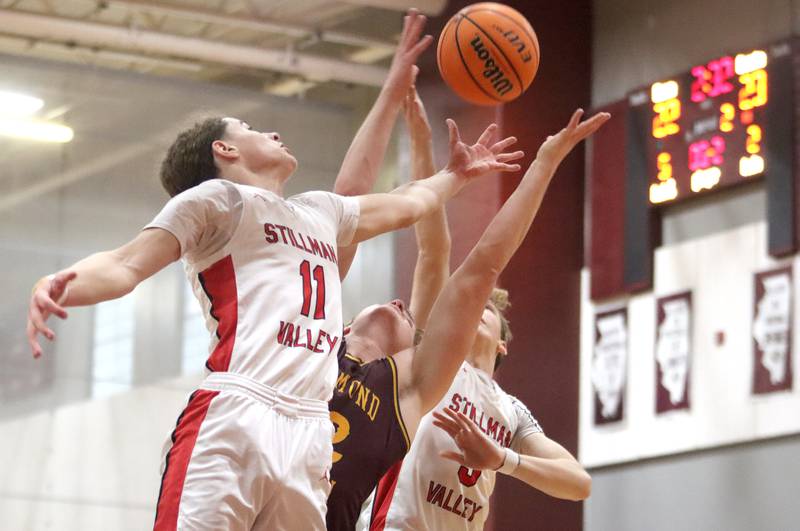 Richmond-Burton’s Ryan Wisniewski, center, reaches for the ball with Stillman Valley’s Evan Eddy, left, and Ian Seper, right, during 74th Annual E.C. Nichols Holiday Classic varsity boys basketball tournament action on Saturday, Dec. 28, 2024 at Marengo High School in Marengo.