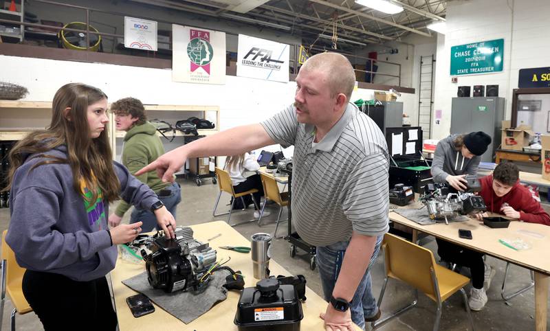 Sycamore High School agriculture teacher Christian Thurwanger asks sophomore Kaitlyn Lisafeld for a tool during a small engines lab Monday, March 14, 2022, at the school. The lab is part of the agriculture program in the Career and Technical Education department at Sycamore High School.