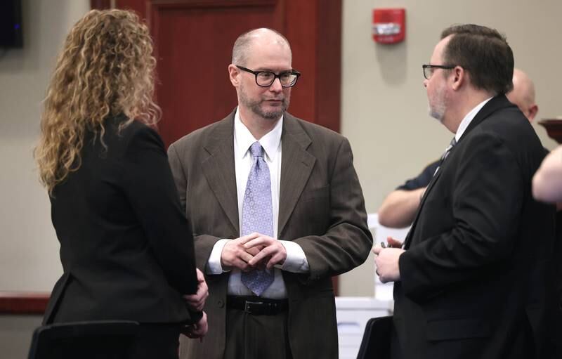 Jonathan Hurst (center) talks to his attorneys Emma Franklin and Chip Criswell Thursday, Jan. 23, 2025, during his trial at the DeKalb County Courthouse in Sycamore. Hurst is charged in the 2016 slayings of Sycamore elderly mother and son Patricia and Robert Wilson.