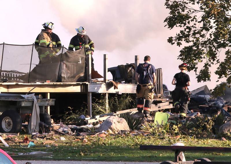 Firefighters overlook the smoldering rubble of a house Tuesday, Oct. 17, 2023, after an explosion at the residence on Goble Road in Earlville. Several fire departments responded to the incident at the single-family home that left one person hospitalized.