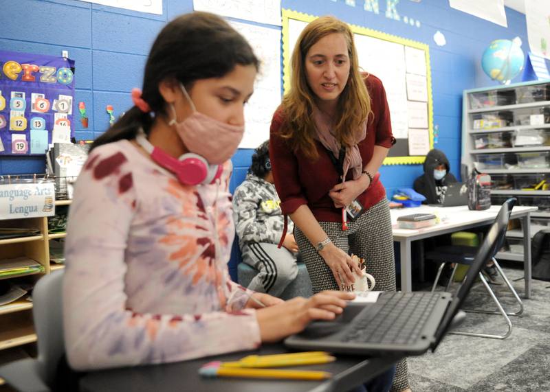 Victoria Garcia Blanco helps Sophia Muro, 10, as she converses with a student in Spain Wednesday, May 18, 2022, during a fifth-grade dual language class at Coventry Elementary School in Crystal Lake. Garcia Blanco, a native of Spain, organized the exchange to connect the students with students from Colegio Sagrado Corazón de Jesús Vedruna, the school in Spain where she previously taught.
